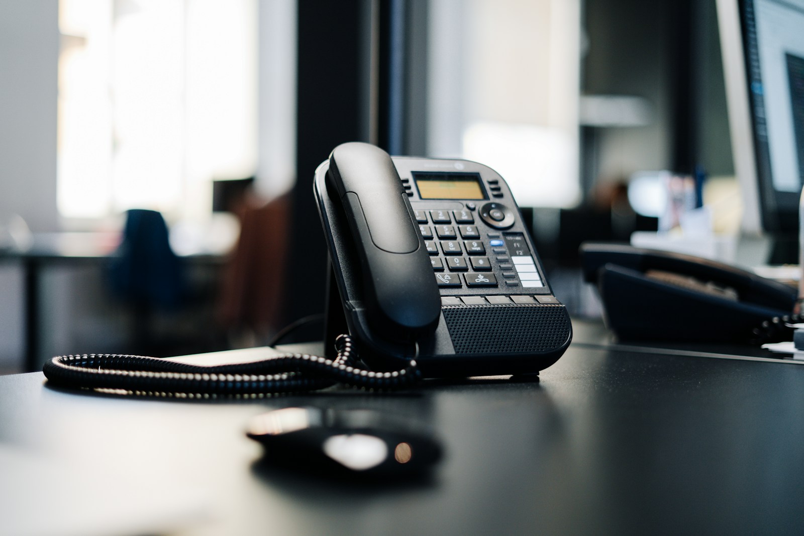 Een telefoon ligt stil op een donker bureau